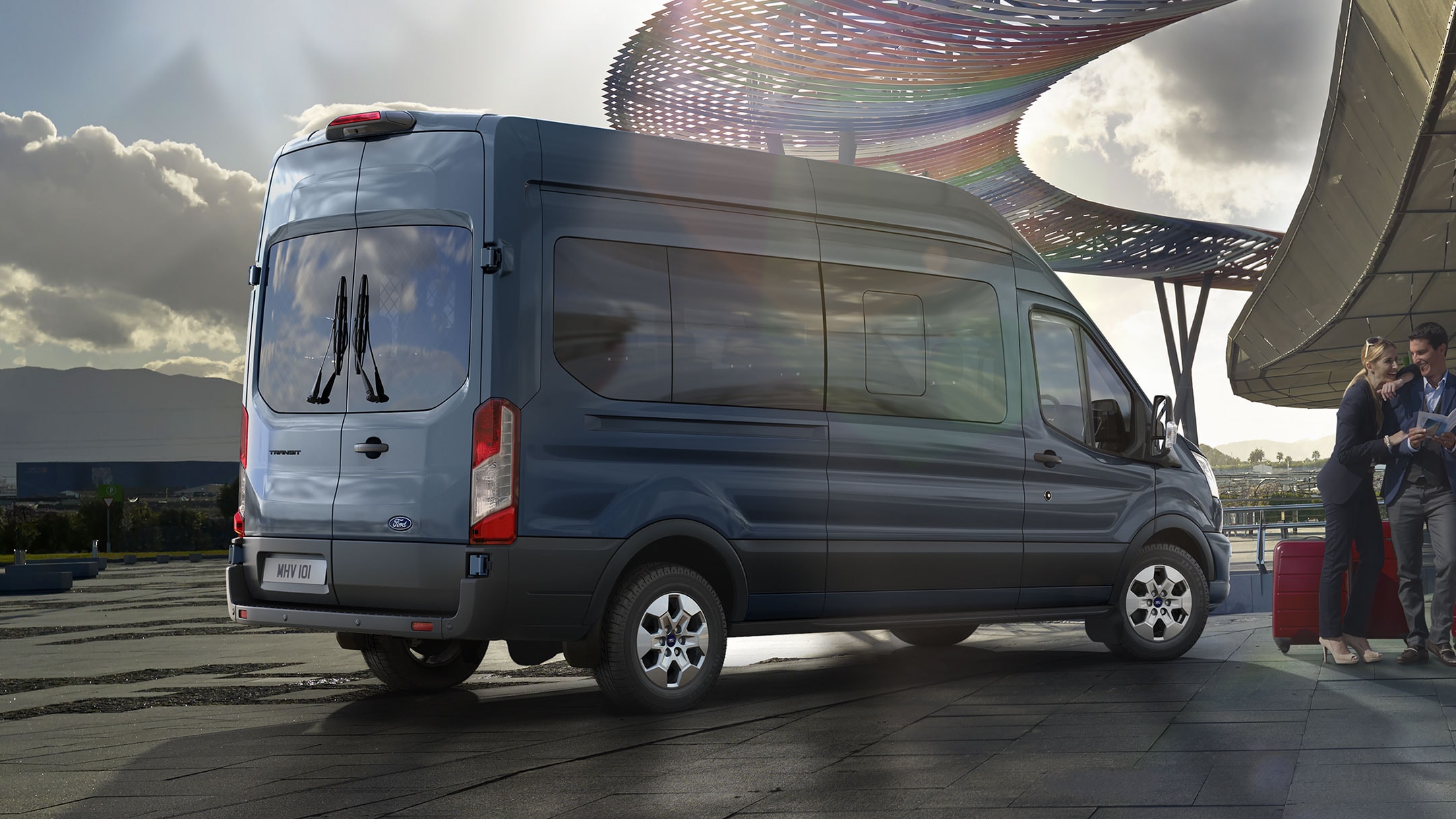 Ford Transit Bus in Blau. Heckansicht, parkt vor Flughafen.