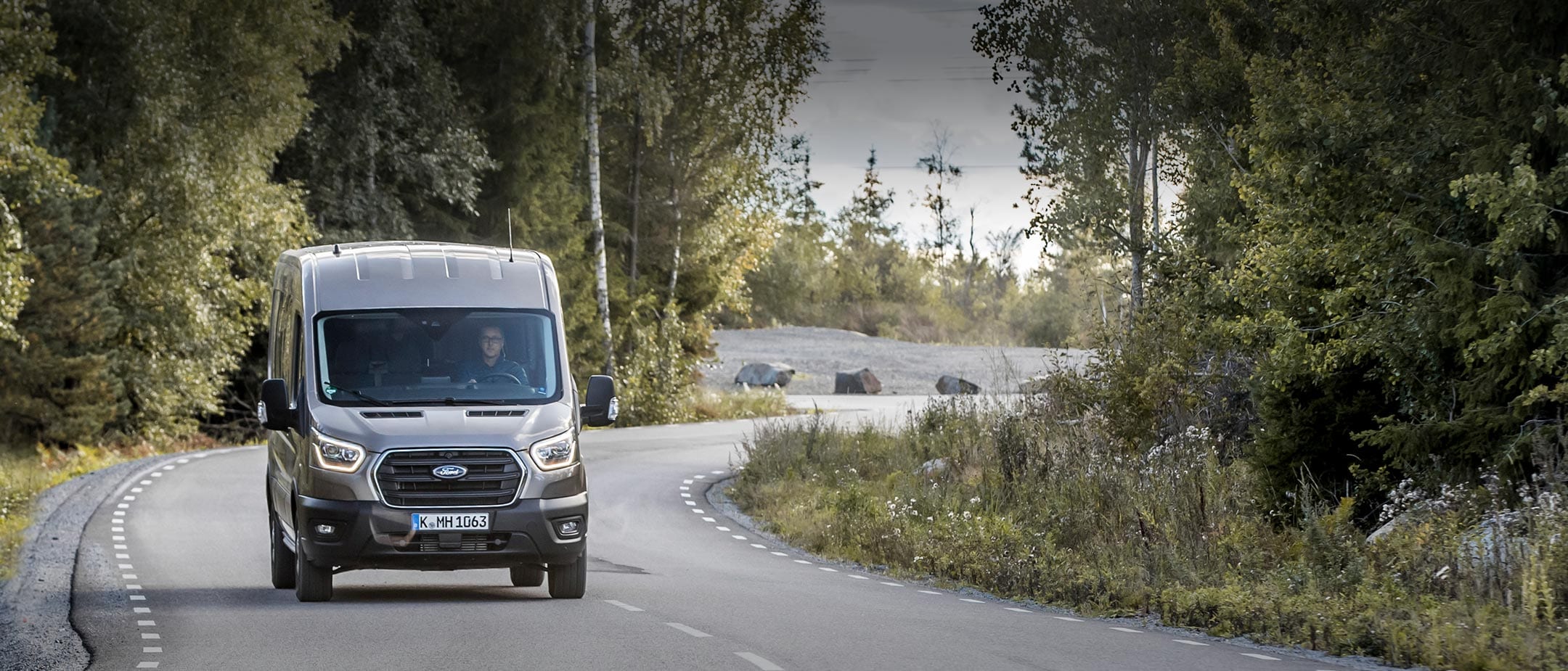 Ford Transit in Silber. Frontansicht, auf einer Landstraße