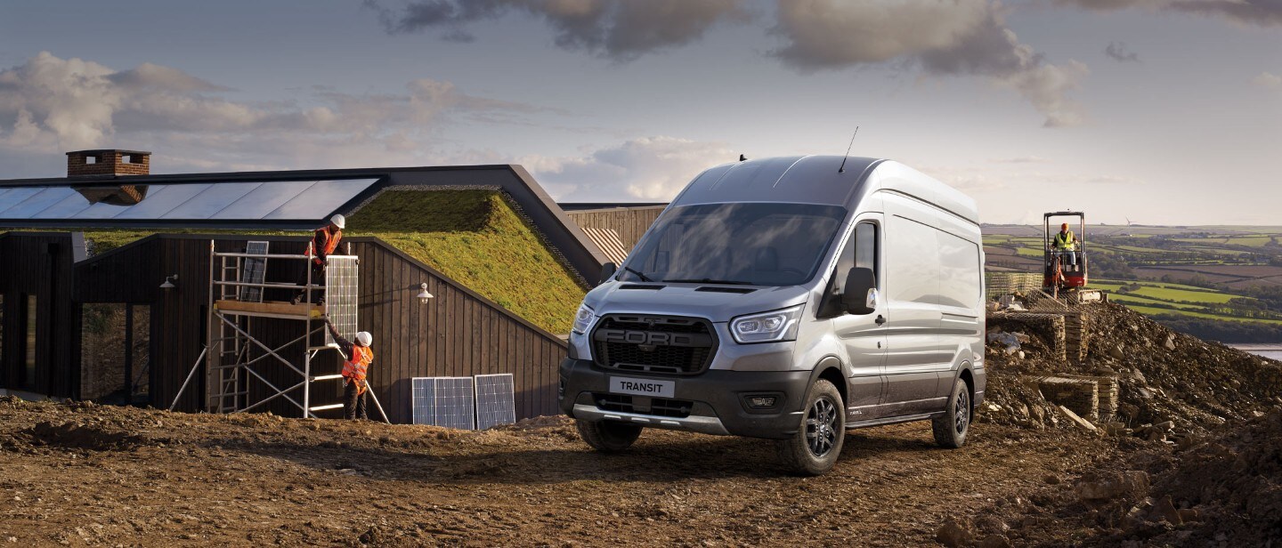 Ford Transit in Silber. Frontansicht, auf einer Baustelle