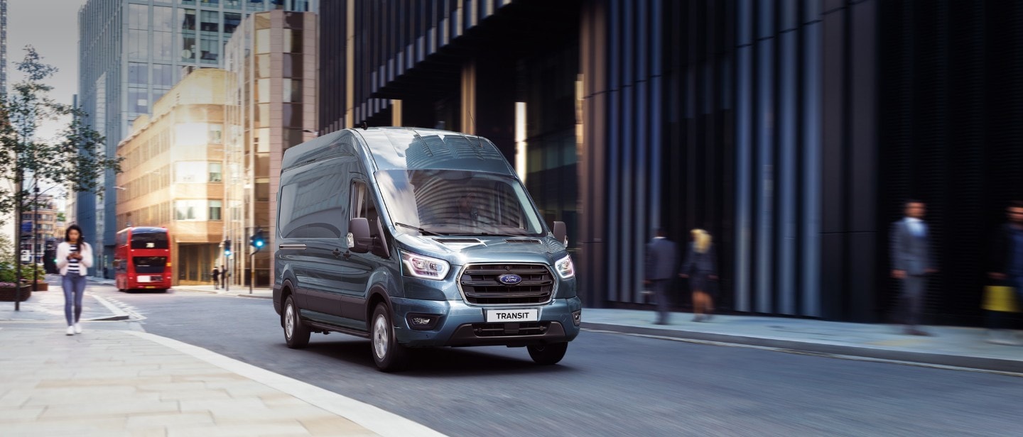 Ford Transit in Blau. Dreiviertelansicht, fährt in einer Stadt