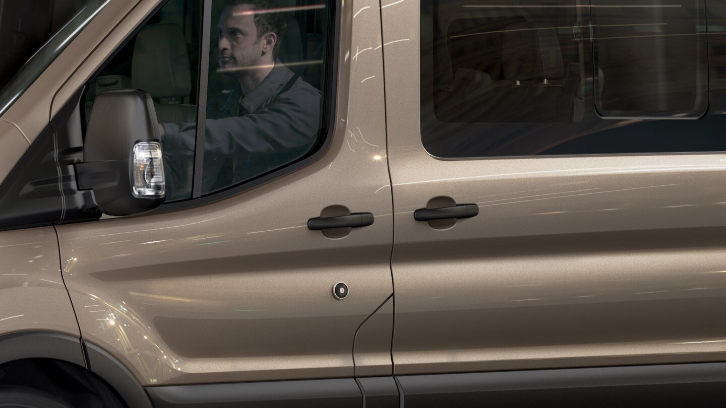 Ford Transit Bus in Silber. Seitenansicht mit Blick auf Fahrer