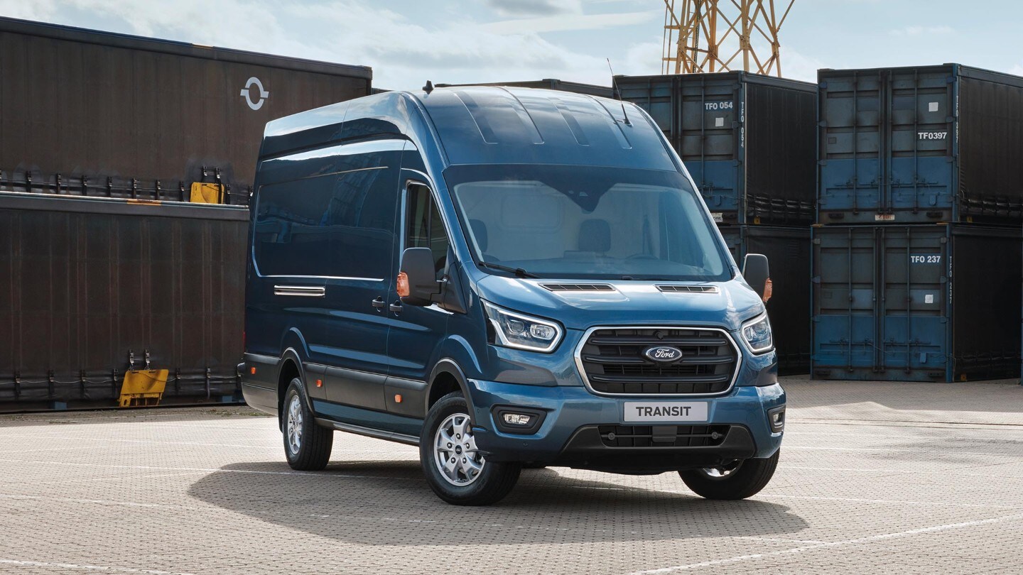 Ford Transit Kastenwagen in Blau. Frontansicht, parkend vor Frachtcontainern