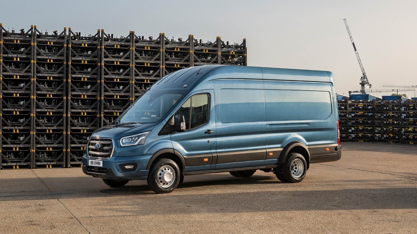 Ford Transit 5 Tonnen Kastenwagen LKW in Blau. Seitenansicht, parkend auf einem Betriebsgelände vor Palettenstapeln