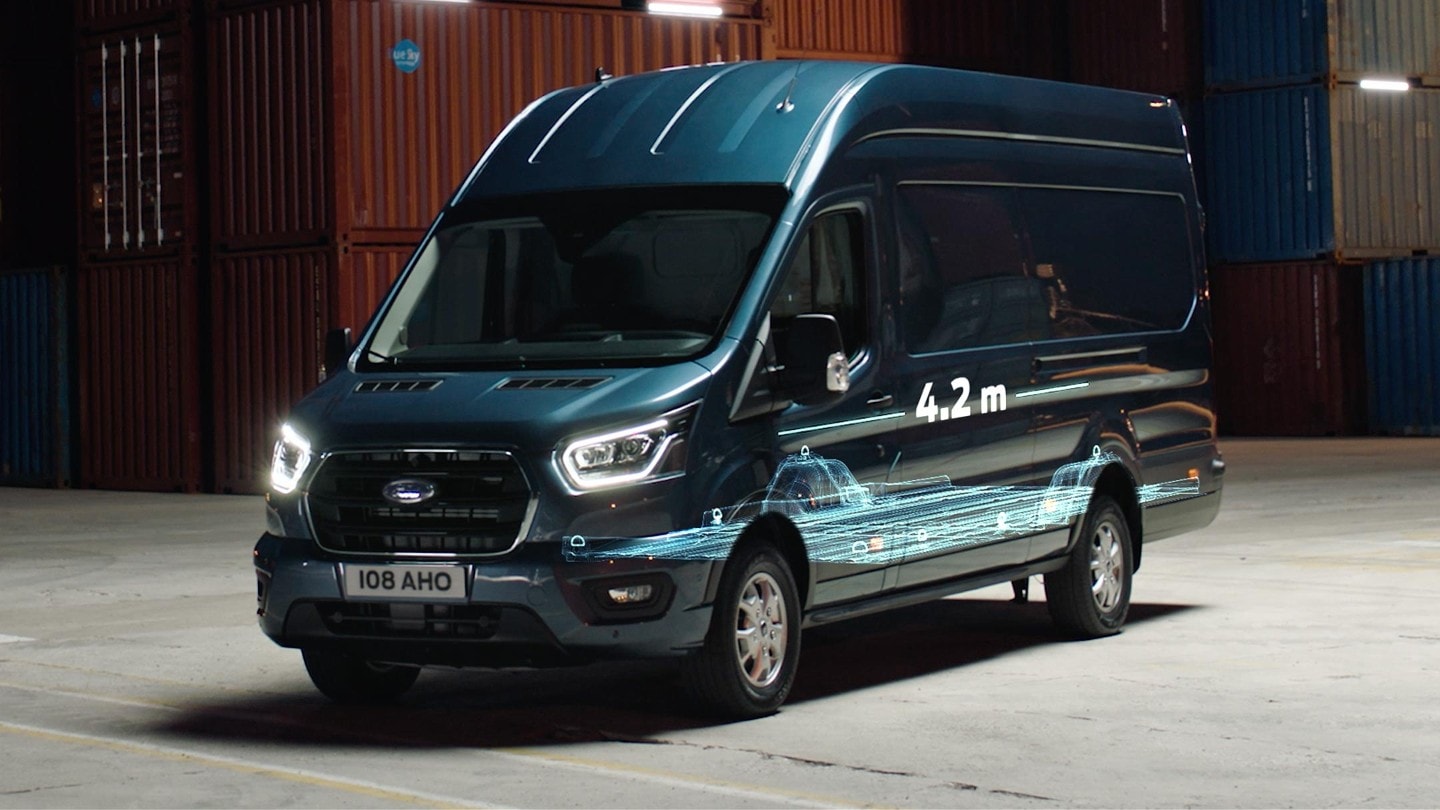 Ford Transit Kastenwagen in Blau. Dreiviertelansicht, parkend vor Containern mit einer Illustration der Laderaumlänge 