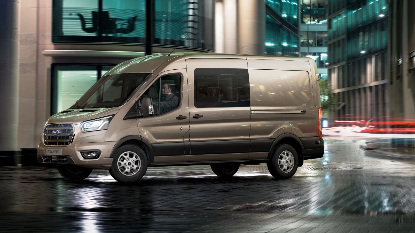 Ford Transit Kastenwagen PKW champagner Seitenansicht parkt in Innenstadt vor Gebäude bei Nacht