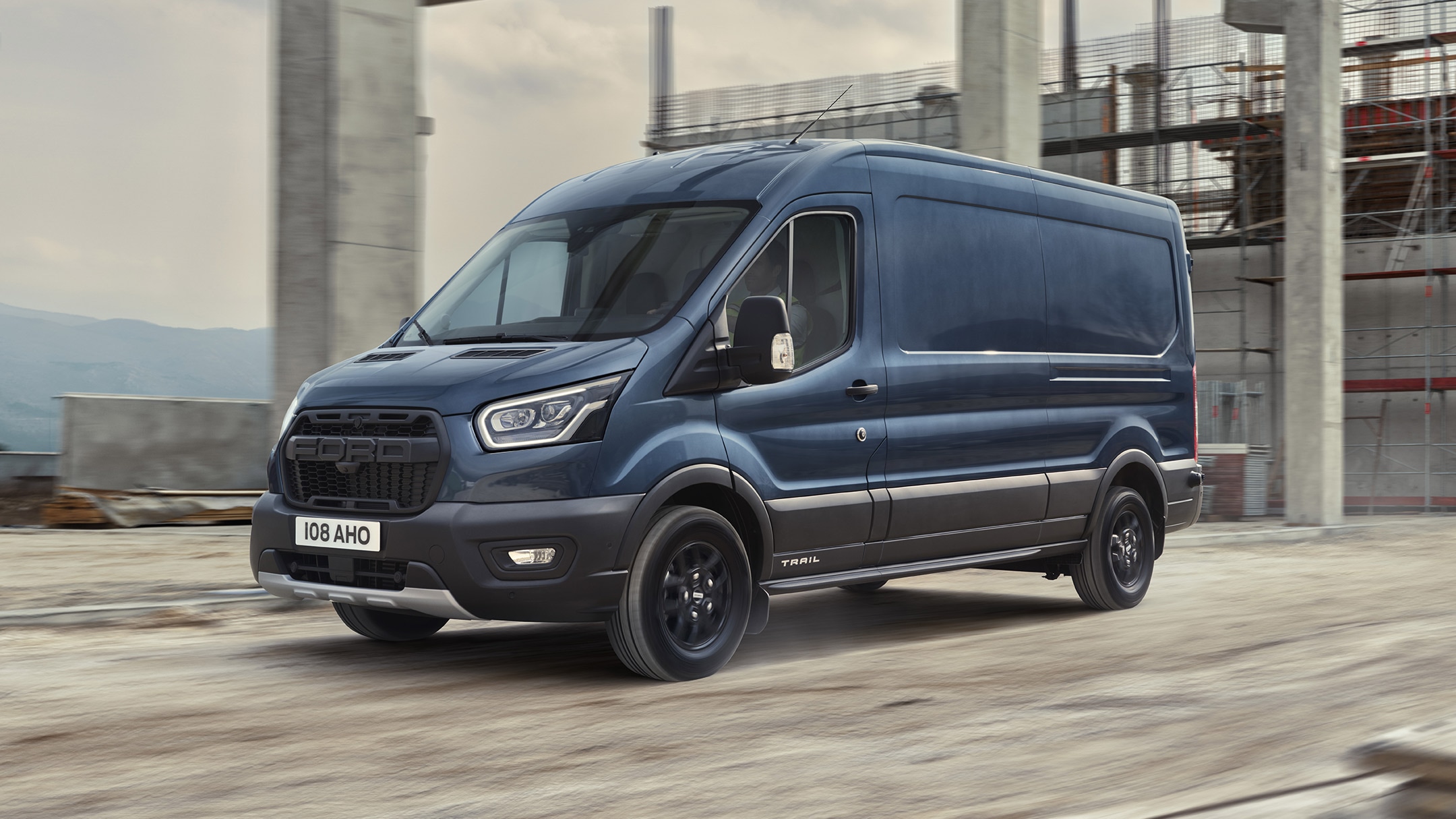 Ford Transit Kastenwagen Trail in Blau. Dreiviertelansicht, fahrend auf einer Baustelle