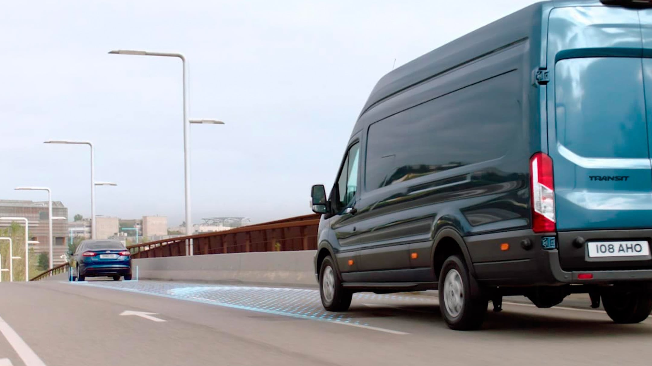 Ford Transit in Blau. Heckansicht, fahrend auf Schnellstraße