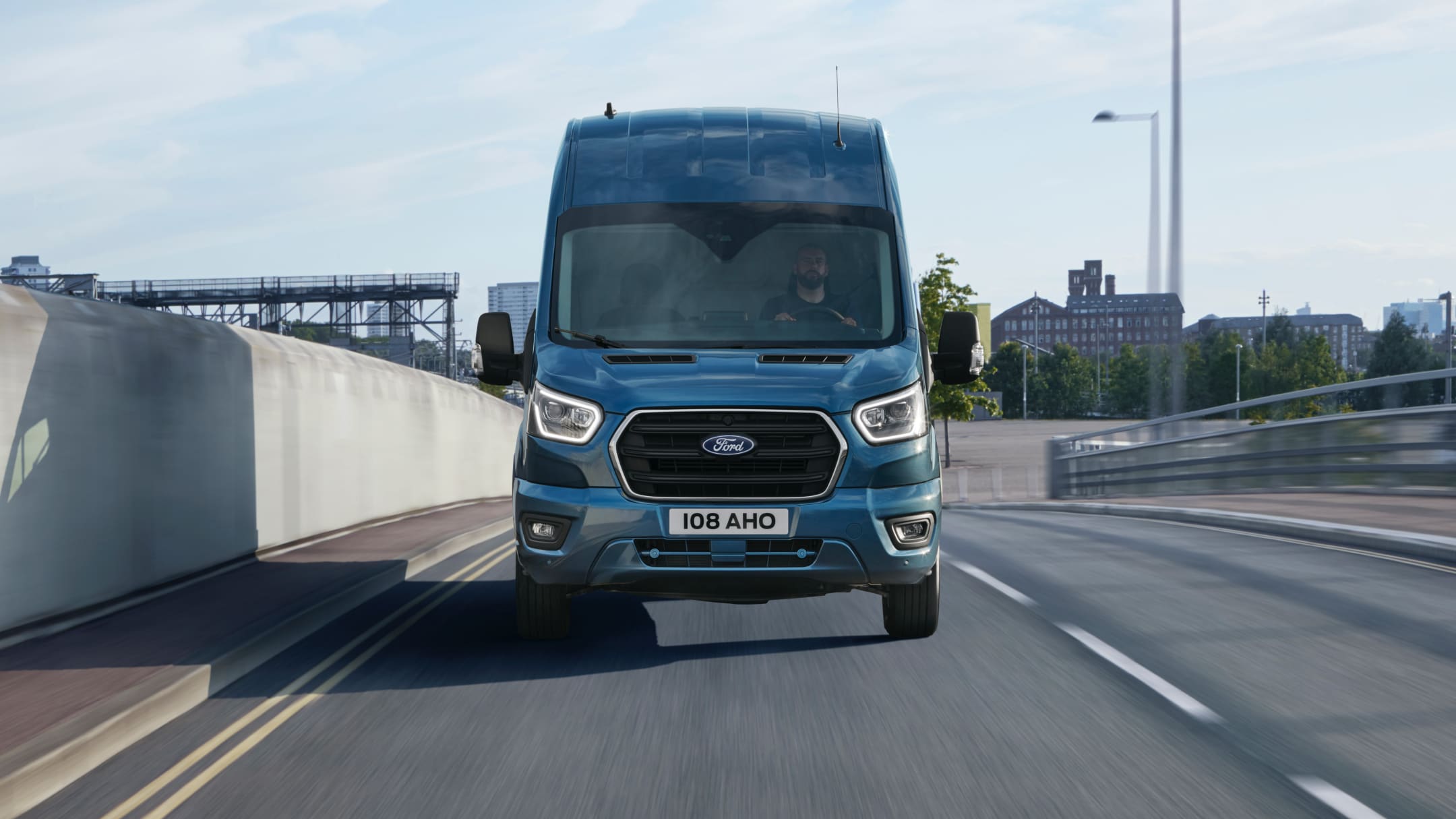 Ford Transit in Blau. Frontansicht, fahrend auf einer Schnellstraße