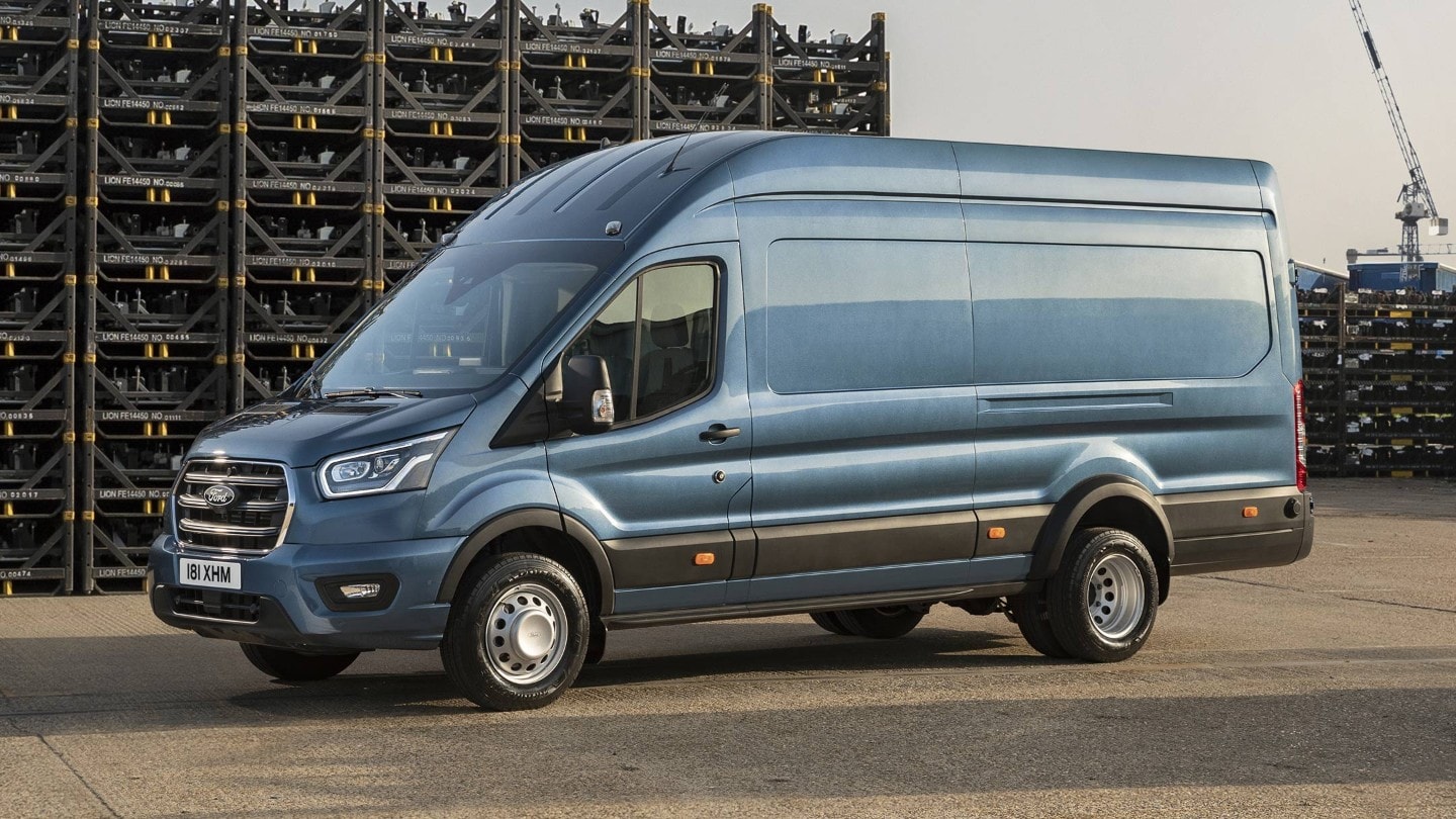 Ford Transit 5 Tonnen Kastenwagen LKW in Blau. Seitenansicht, parkend auf einem Betriebsgelände vor Palettenstapeln