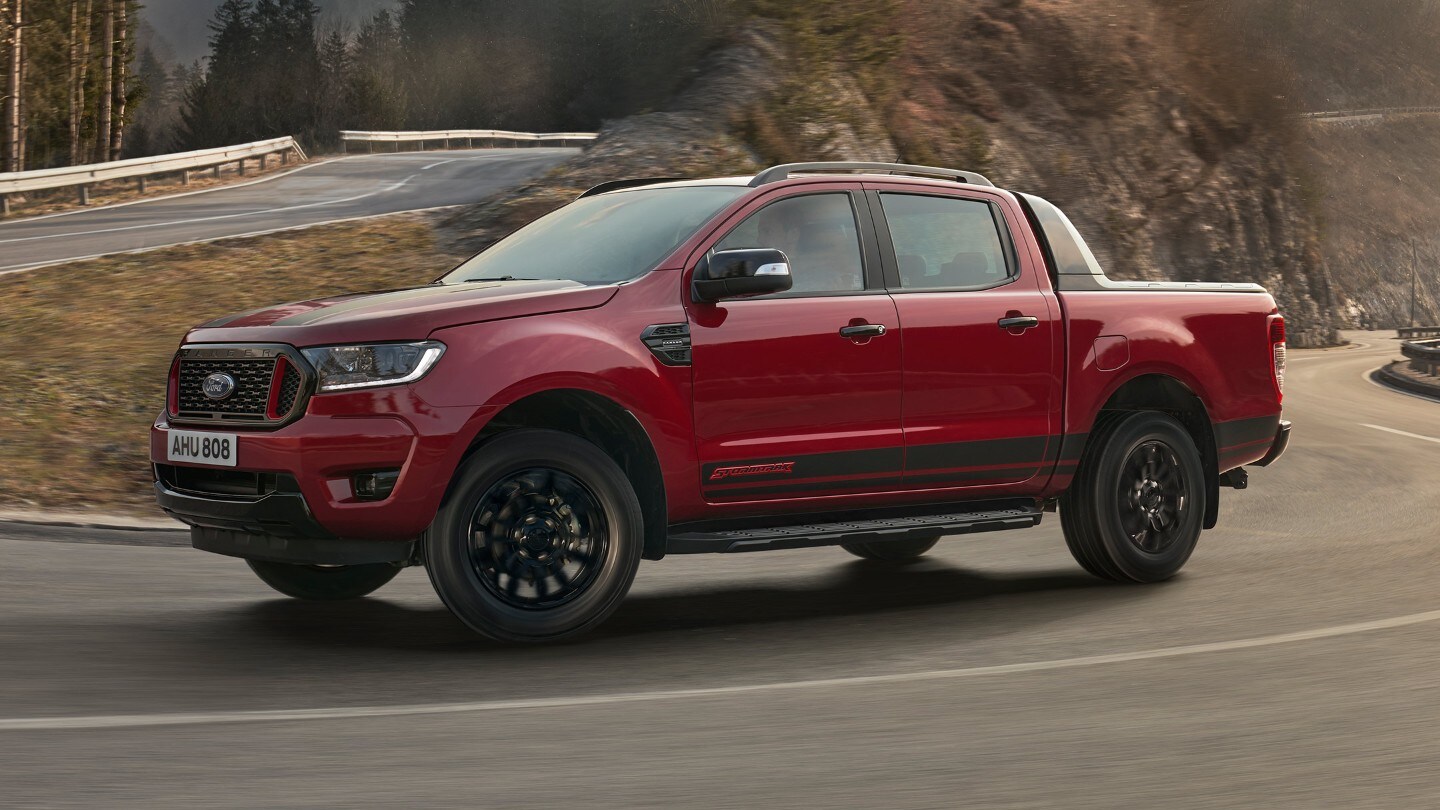 Ford Ranger Stormtrak in Rot. Seitenansicht, bergauf fahrend auf einer Gebirgsstraße