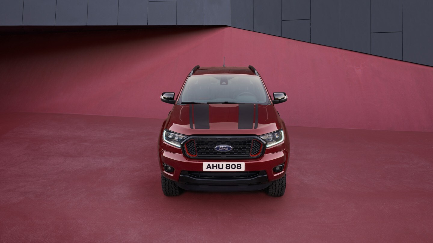 Ford Ranger Stormtrak in Rot. Frontansicht, parkend auf rotem Untergrund