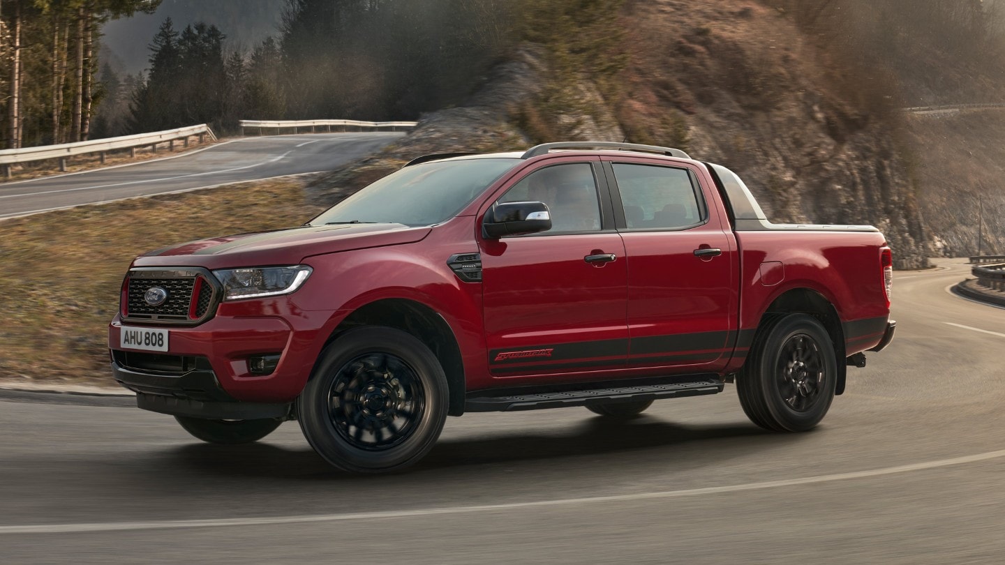 Ford Ranger Stormtrak in Rot. Seitenansicht, bergauf fahrend auf einer Gebirgsstraße
