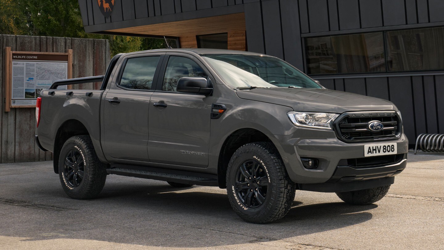 Ford Ranger Wolftrak in Grau. Dreiviertelansicht, parkend vor einem modernen Gebäude