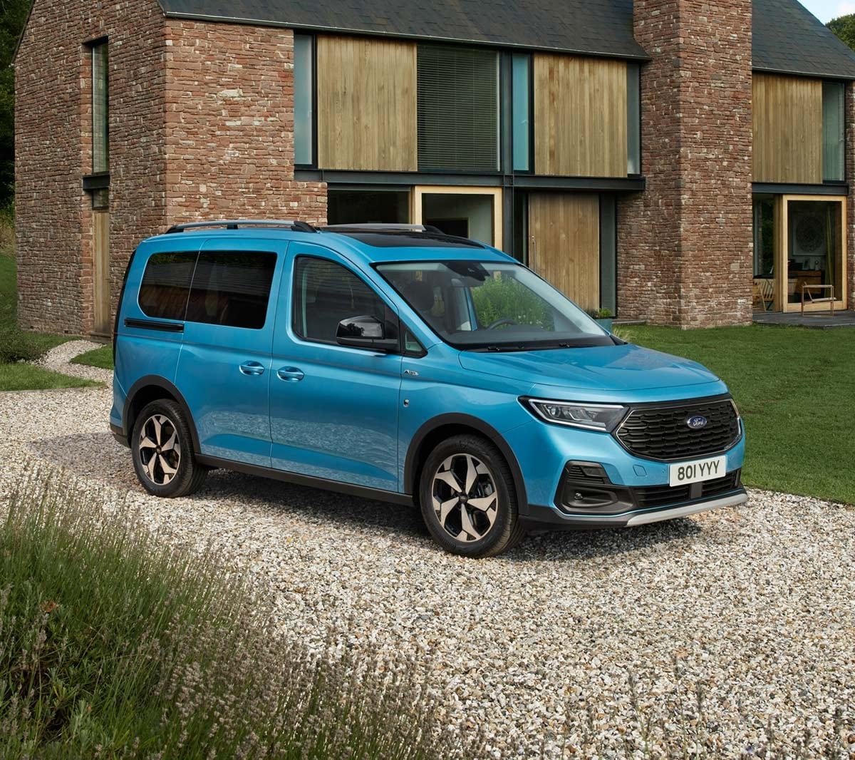 Ford Tourneo Connect in Blau. Dreiviertelansicht, parkend auf Kiesweg vor Wohnhaus