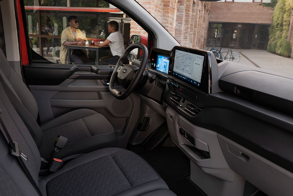 Ford Transit Custom Innenraum. Ansicht auf vordere Sitzreihe, Lenkrad und Touchscreen.