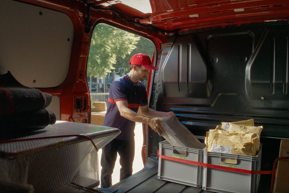 Ford Transit Custom Innenraum. Person belädt die Boxen im Laderaum.