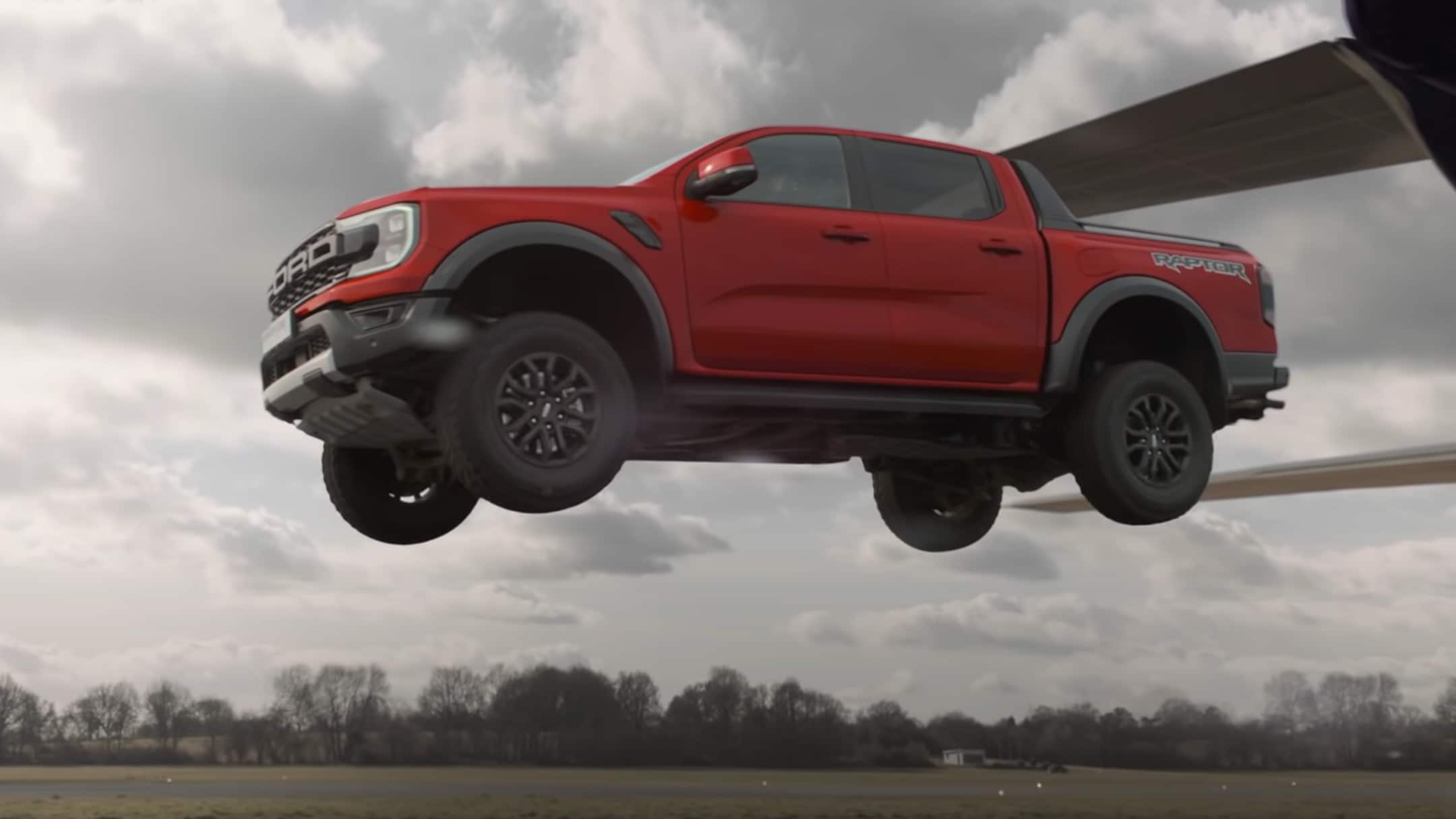 Ford Ranger Raptor in Rot. Fahrend über einen Flugplatz und felsiger Umgebung - Video 