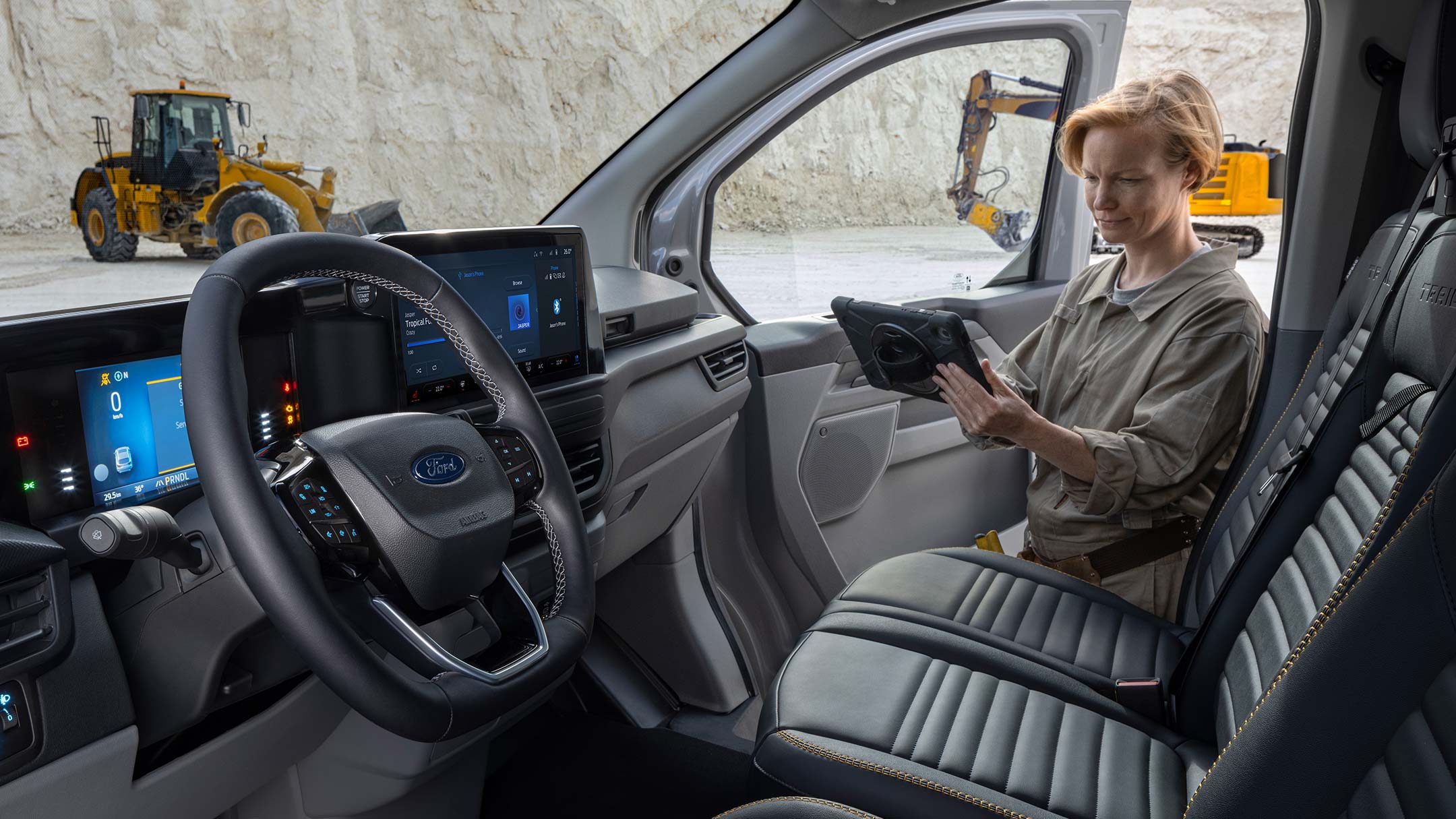 Ford Transit Custom Innenraum. Blick in Fahrerkabine und Frau hält ein Tablet. 