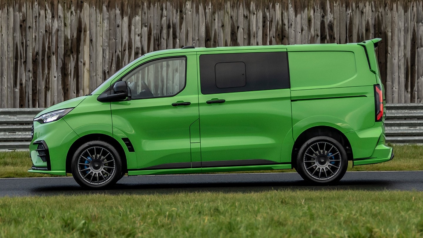 Ford Transit Custom MS-RT in Grün. Seitenansicht, stehend vor einer Wand. 