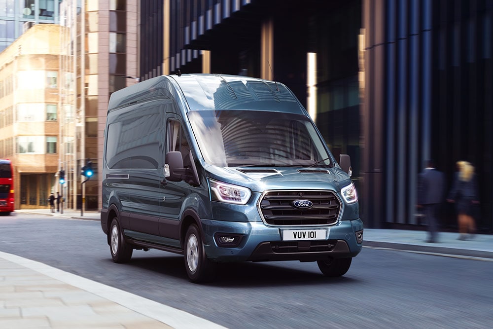 Ford Transit in Blau. Dreiviertelansicht, fährt in einer Innenstadt.