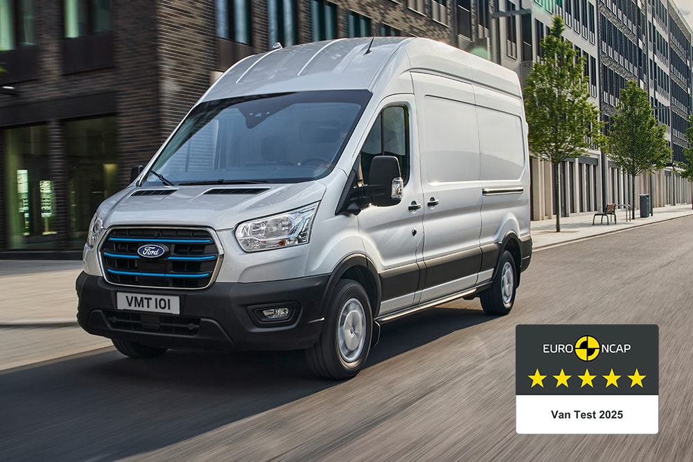 Ford E-Transit Kastenwagen in Silber. Dreiviertelansicht, fährt durch die Stadt.