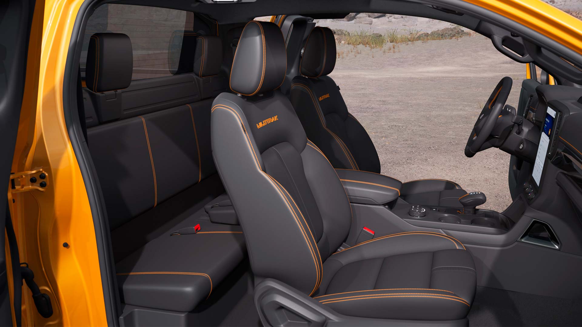 Blick von der Beifahrerseite in den Innenraum eines orangen Ford Ranger Extrakabine.