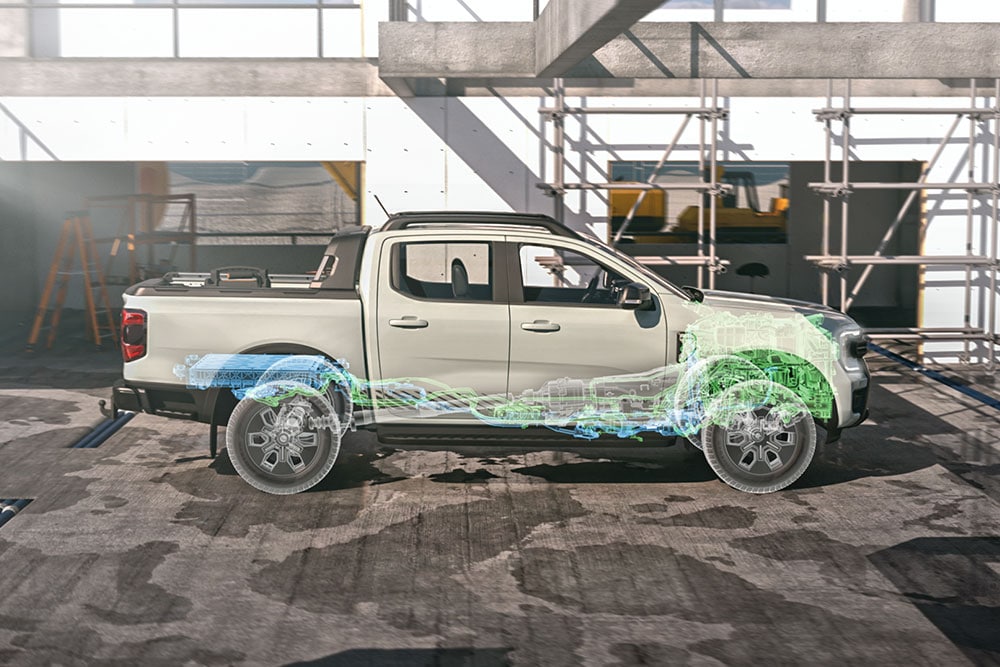 Ford Ranger Plug-in-Hybrid in Weiß. Seitenansicht, stehend vor einer Baustelle.