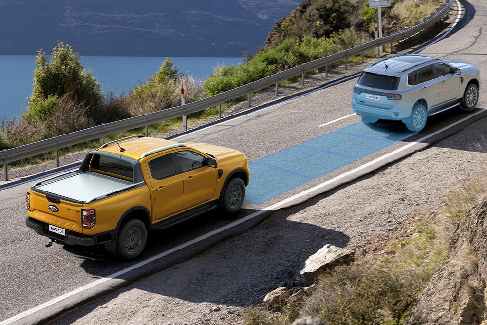 Ford Ranger in Orange. Fährt eine Autobahn entlang mit Visualisierung des Post-Collision-Assist.