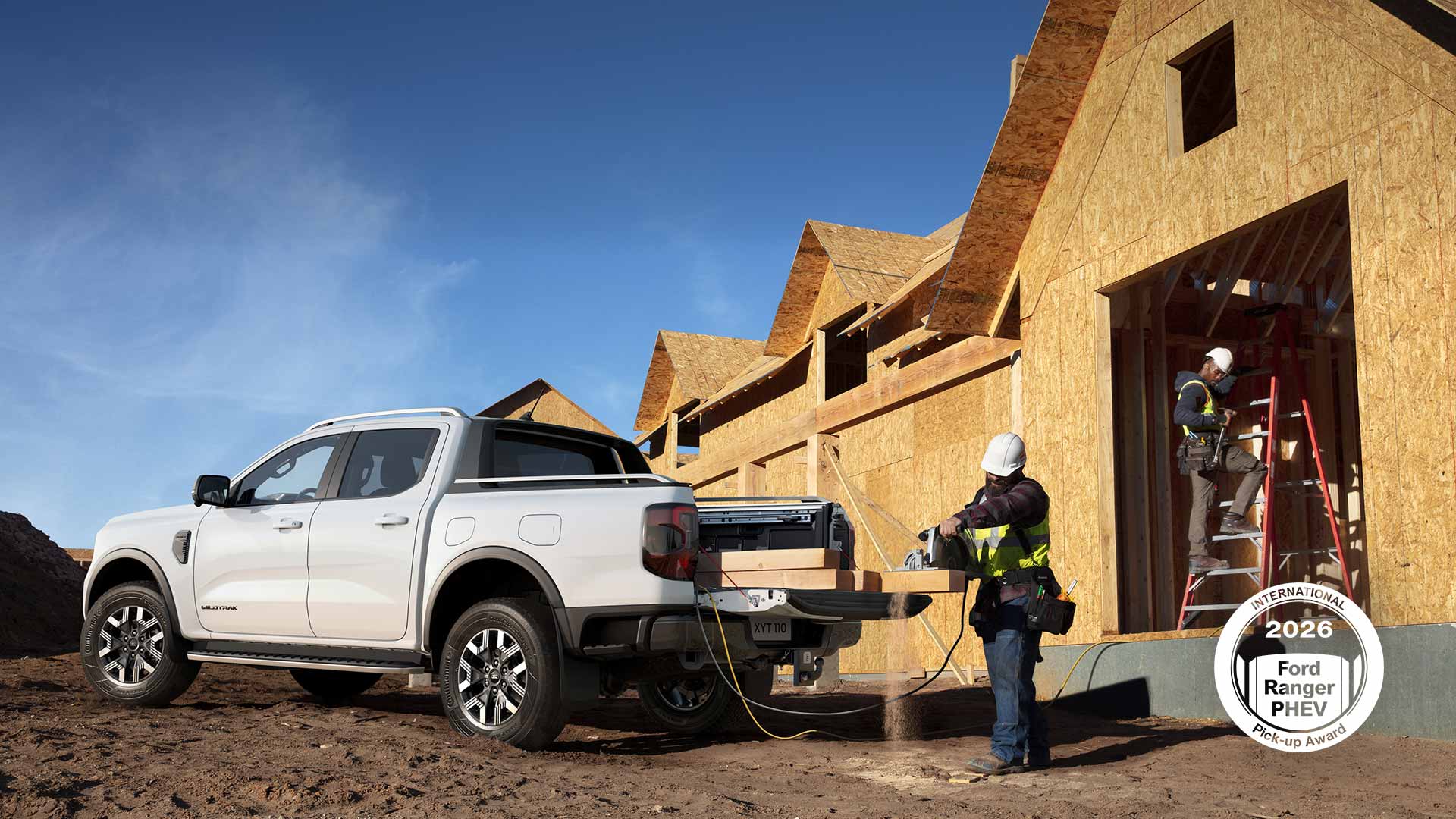 Ford Ranger Pick-up in weiß auf einer Baustelle, der eine Säge mit Strom versorgt, während ein Arbeiter Holz schneidet.