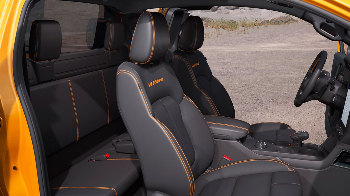 Blick von der Beifahrerseite in den Innenraum eines orangen Ford Ranger Extrakabine.