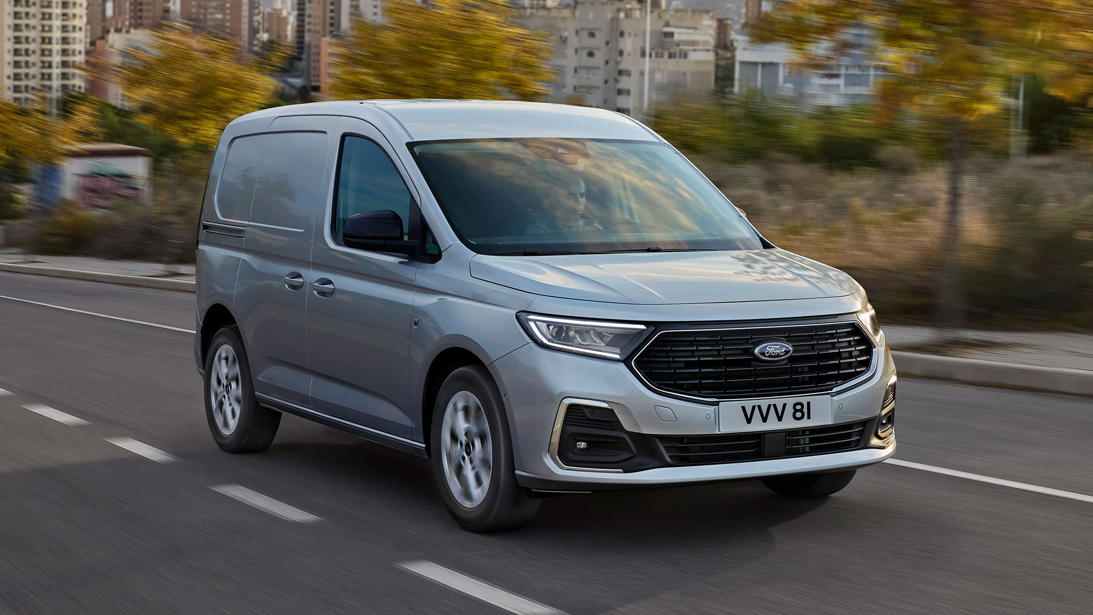 Ford Transit Connect in Silber. Dreiviertansicht, fährt auf einer Straße.