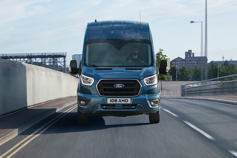 Ford Transit Kastenwagen in Blau. Frontansicht, fährt auf einer Autobahn.