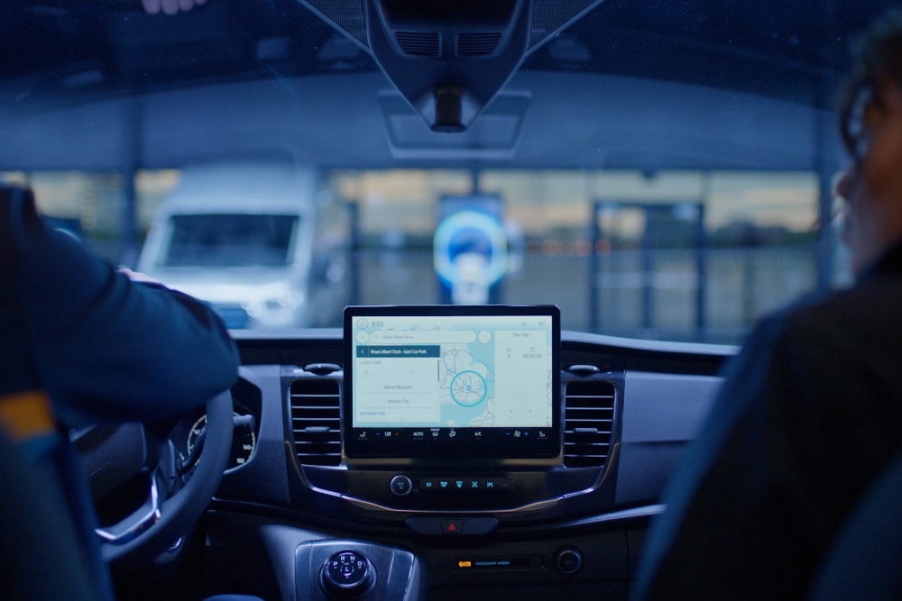 Ford E-Transit Fahrgestell Innenraum. Zwei Personen vor dem Cockpit mit 12-Zoll-Touchscreen.