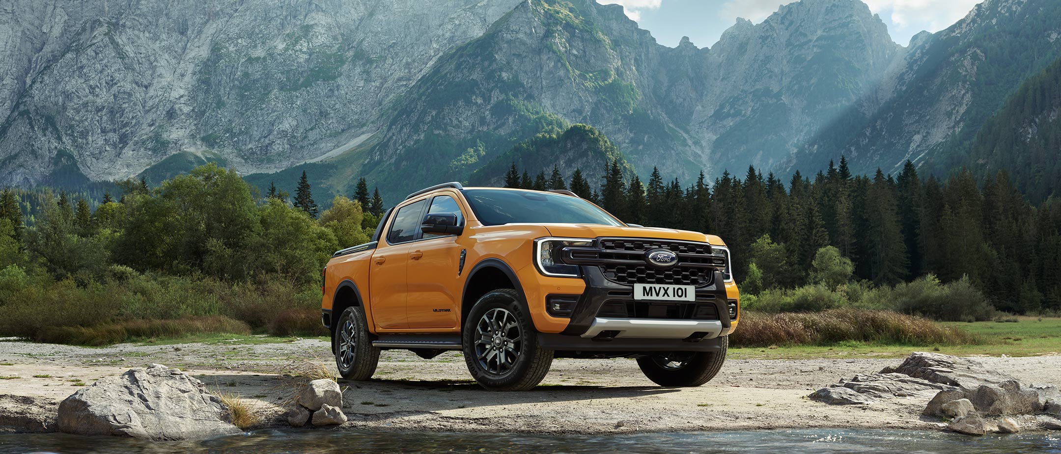 Ford Ranger in Orange. Dreiviertelansicht, parkt vor Berglandschaft