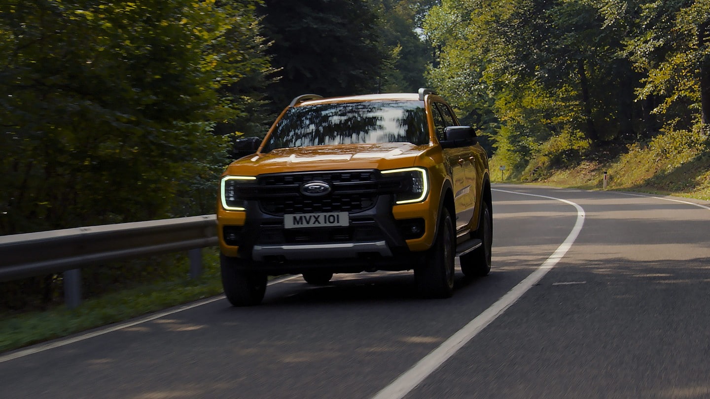 Ford Ranger in Orange. Frontansicht, fährt auf einer Landstraße