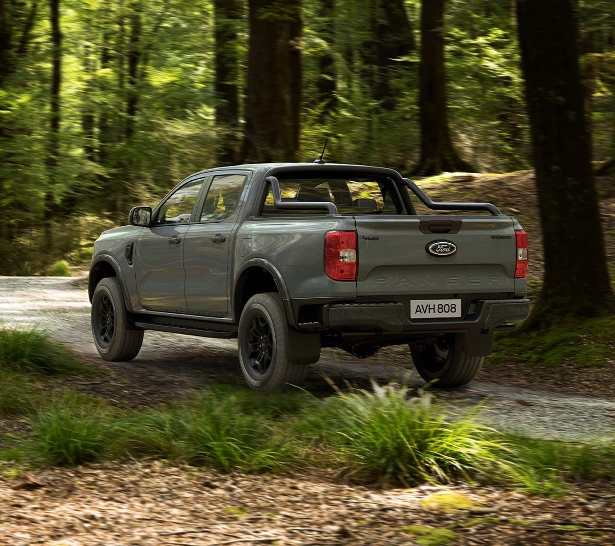 Ford Ranger Tremor in Grau. Heckansicht, fahrend durch einen Wald.