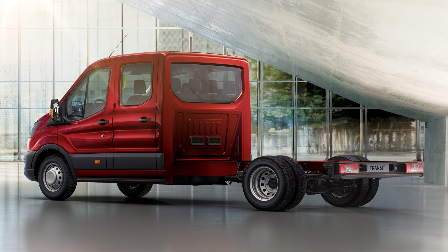 Ford Transit Fahrgestell Doppelkabine in Rot. Dreiviertelansicht, parkend in einer Ausstellungshalle