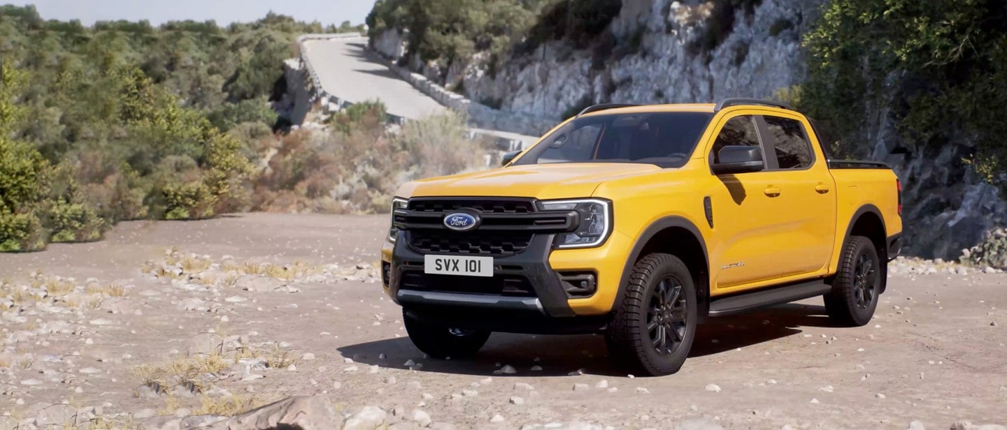 Ford Ranger in Gelb. Dreiviertelansicht, in einem hügeligen Gebiet