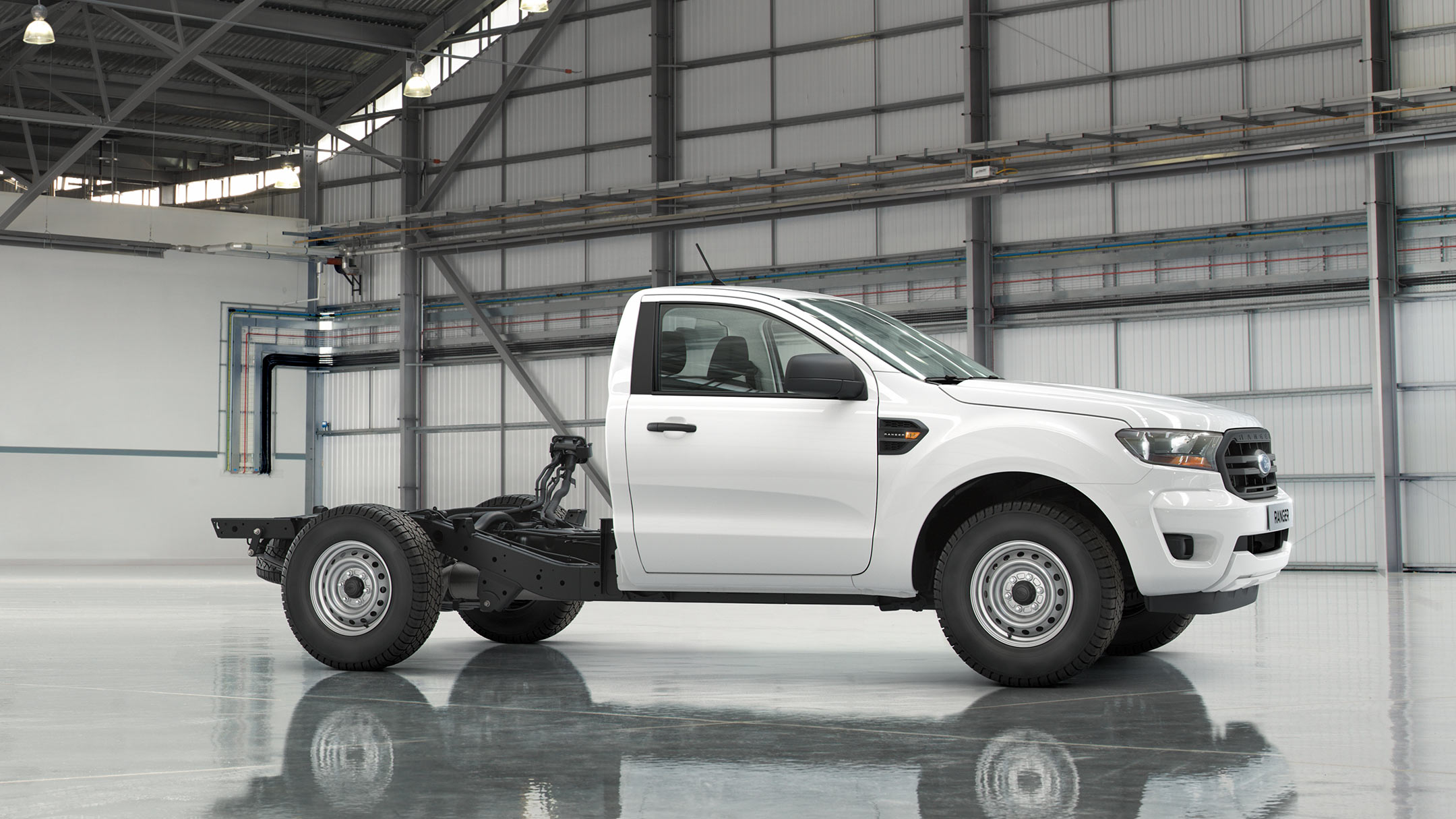 Ford Ranger Einzelkabine Fahrgestell in Weiß. Seitenansicht, parkend in Ausstellungshalle