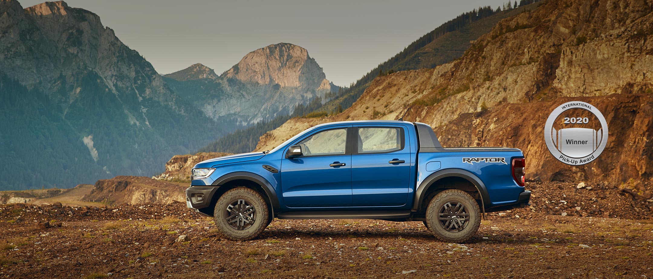Blue Ford Ranger Raptor parked on snowy mountains