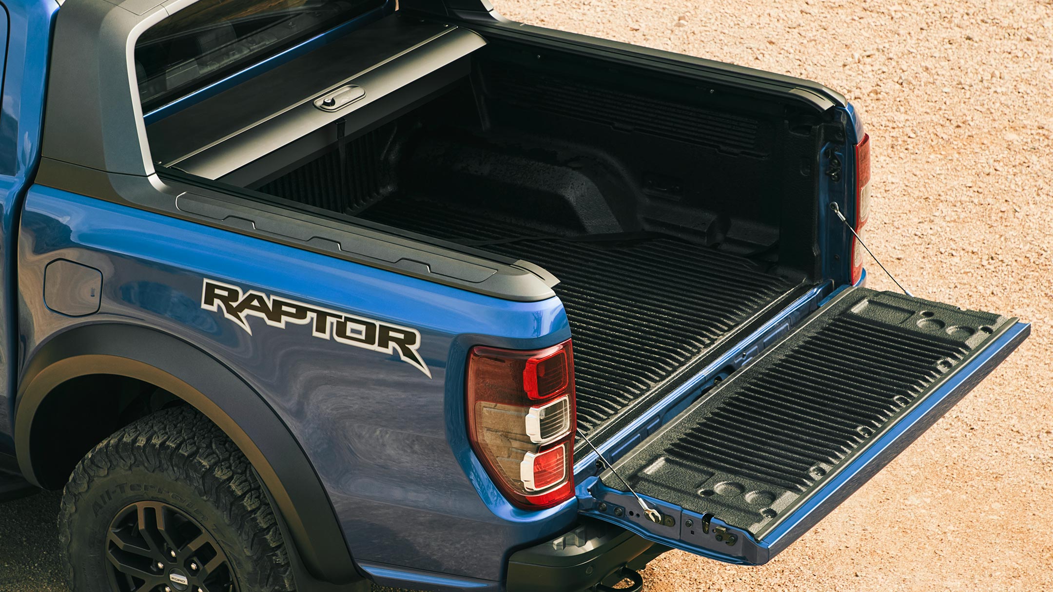 Ford Ranger Raptor in Blau. Dreiviertelansicht von hinten, Ladefläche mit geöffneten EasyLift Heckklappe