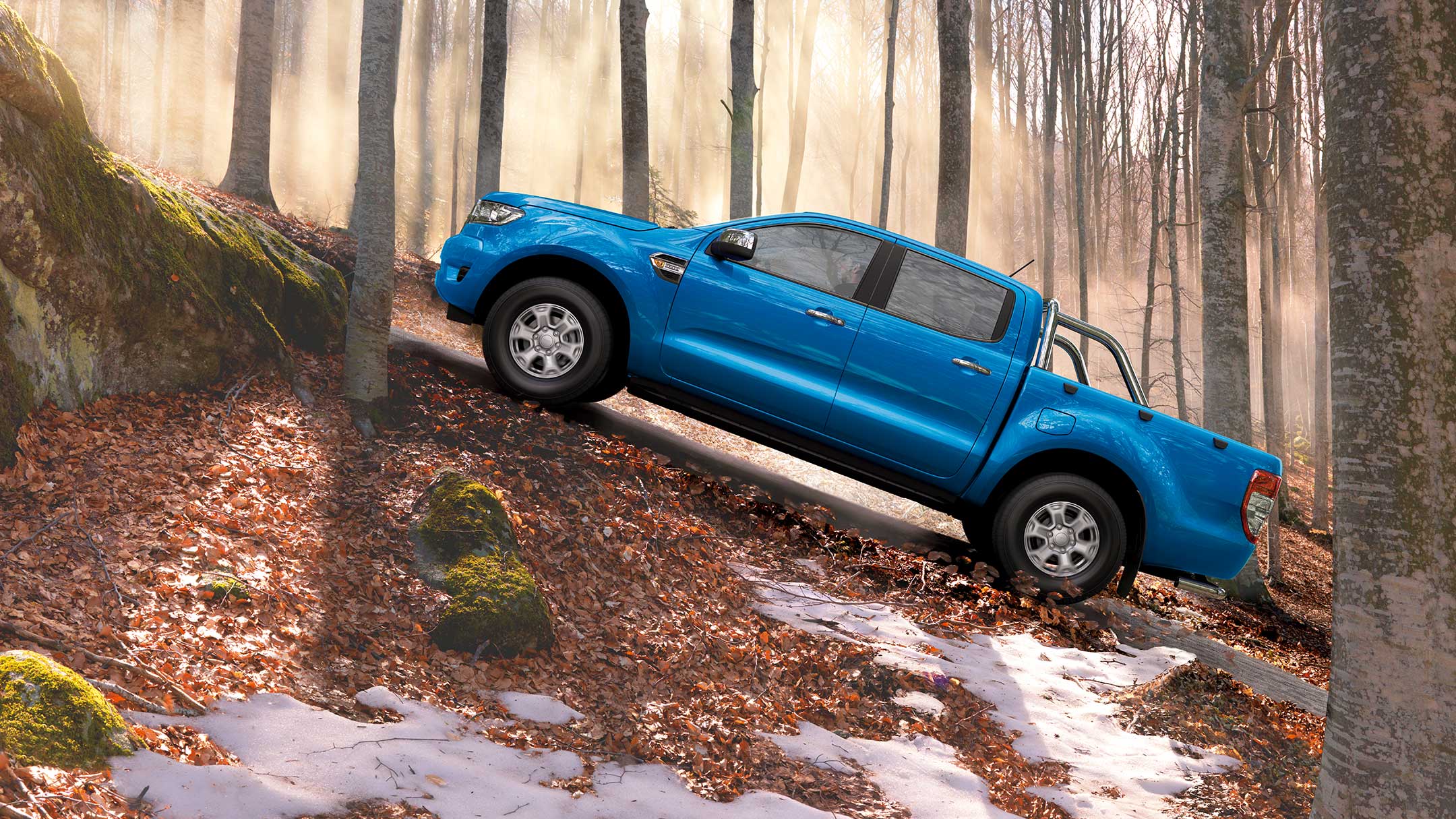 Ford Ranger in Blau. Seitenansicht, bergauf fahrend