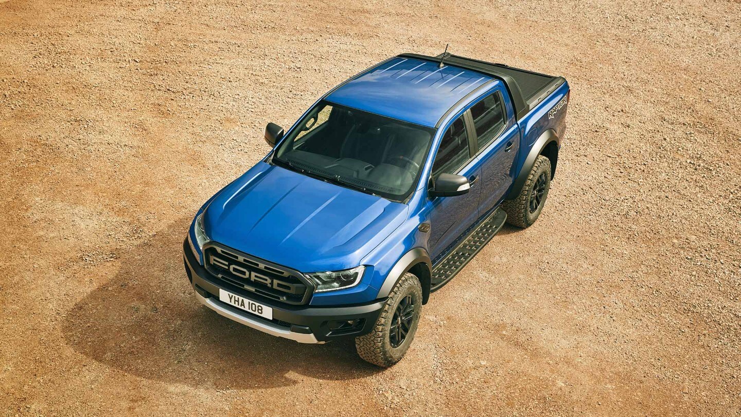Ford Ranger Raptor in Blau. Dreiviertelansicht von oben, parkend auf einem Schotterplatz
