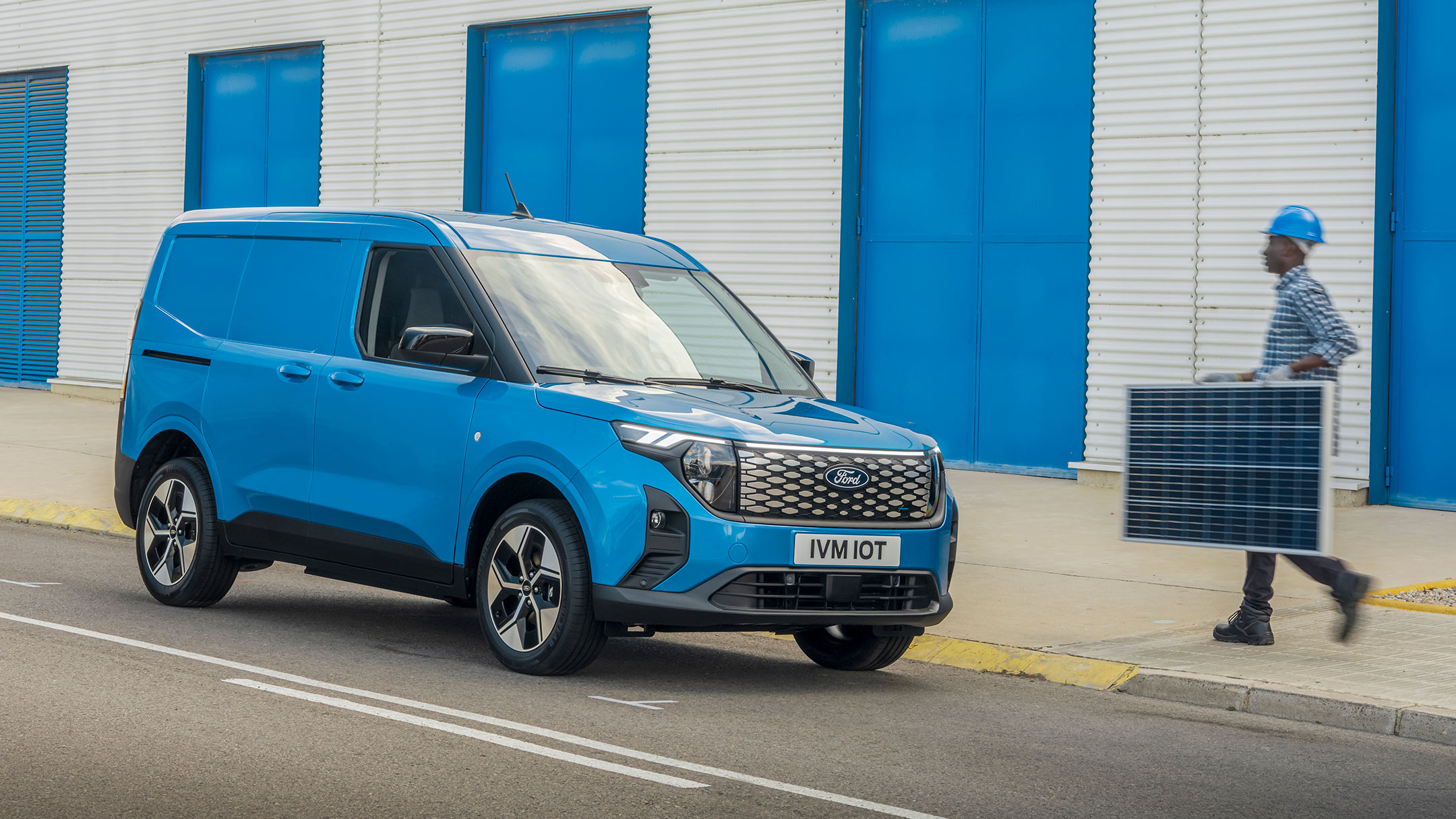 Ford E-Transit Courier in Blau. Dreiviertelansicht, parkt am Straßenrand
