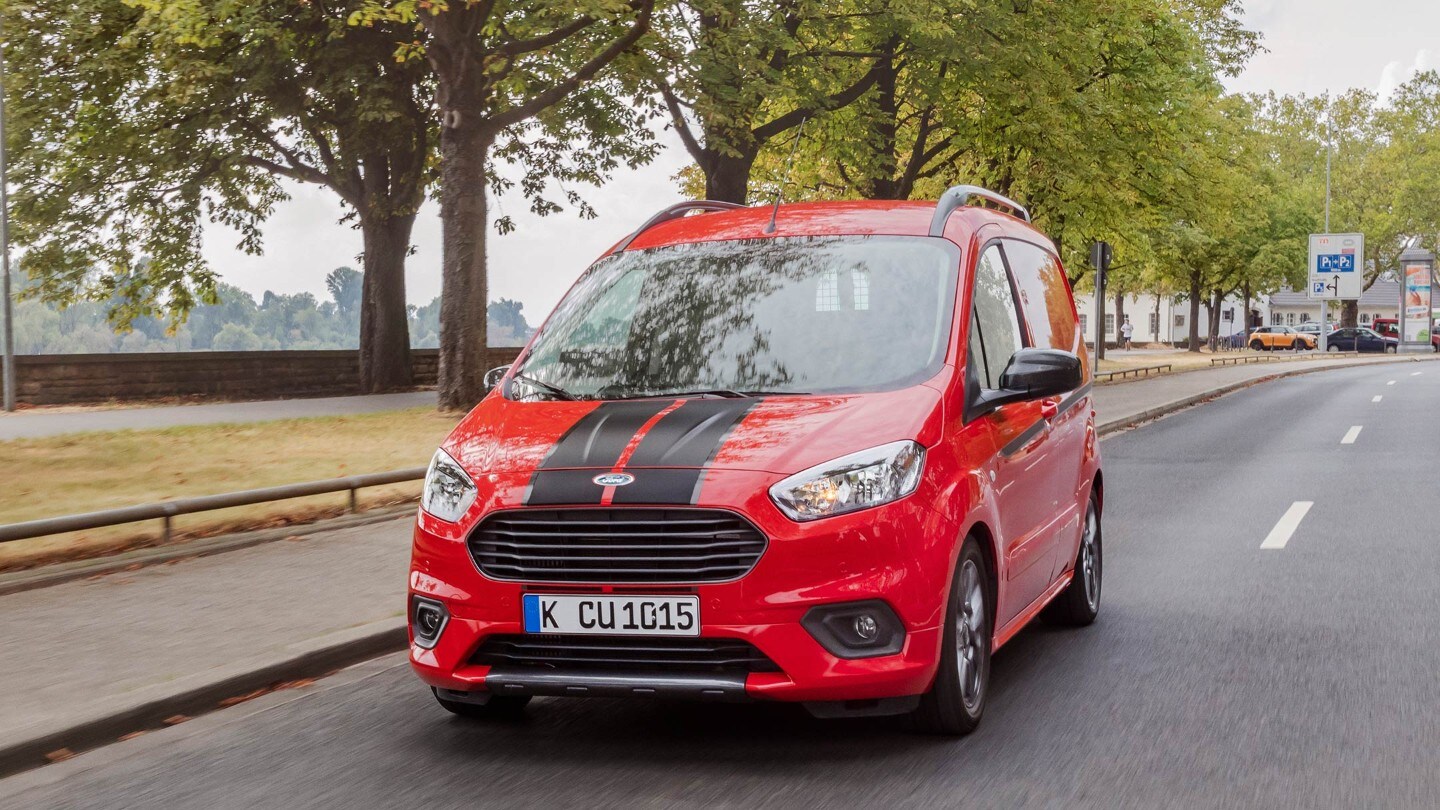 Ford Transit Courier Kastenwagen in Rot. Frontansicht, fahrend auf einer Straße