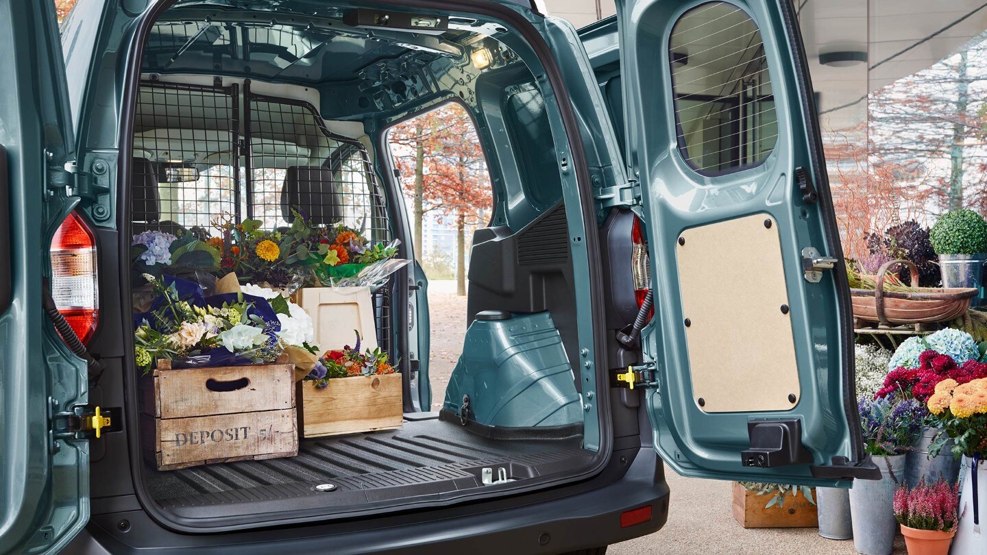 Ford Transit Courier in Blau. Heckansicht, parkend vor einem Blumengeschäft mit geöffneten Hecktüren und seitlicher Schiebetür