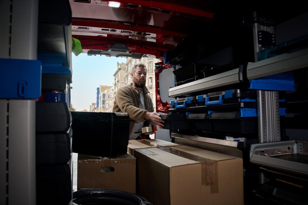 Innenansicht eines Mannes, der einen Ford-Transporter belädt.