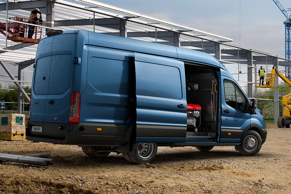 Blauer Ford Pro Transit Transporter parkt auf einer Baustelle.