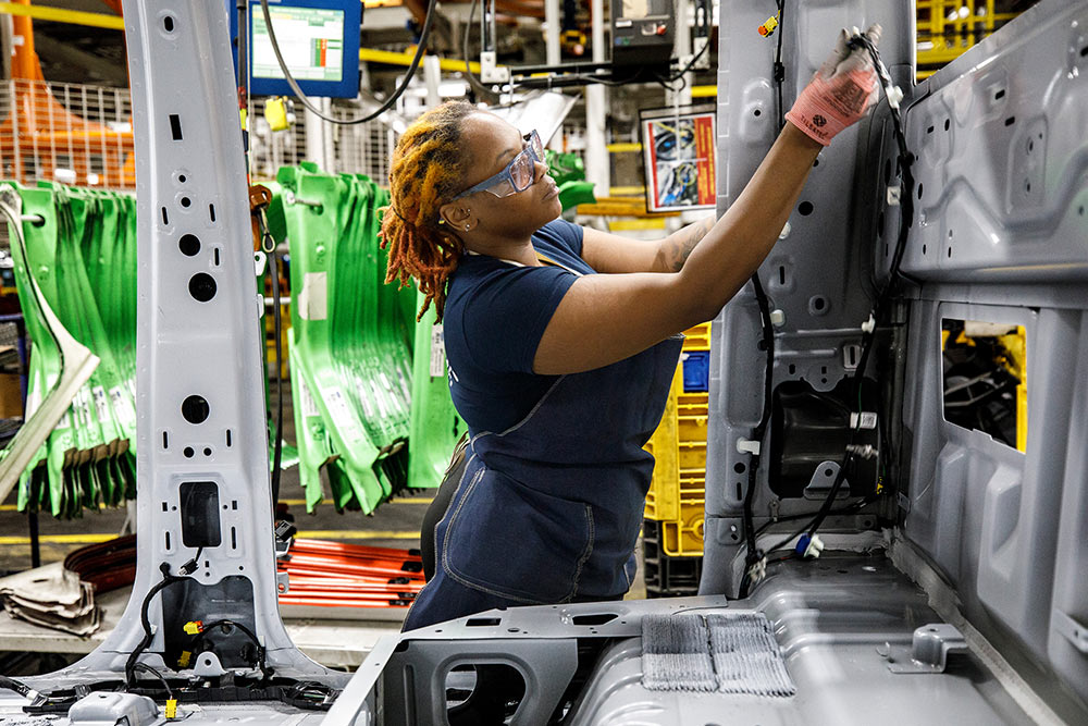 Ford-Mechaniker arbeitet an einem Transporter in einer Werkstatt.