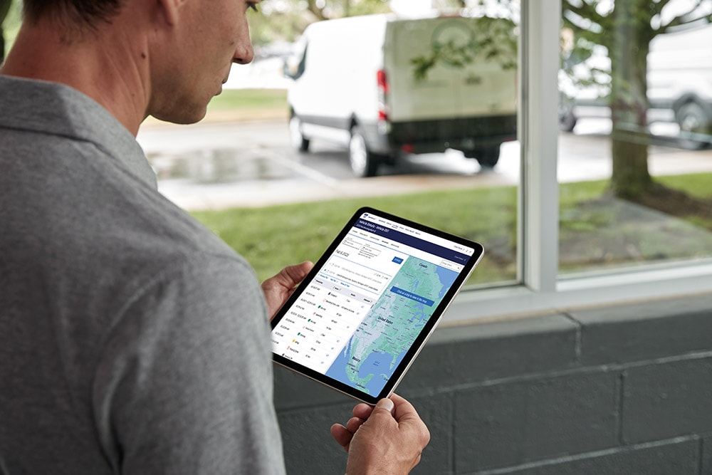 Mann betrachtet seine Ford-Fahrzeugdaten auf einem Tablet und überwacht sie live.